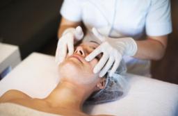 Kosmetyczka w maseczce i rękawiczkach zrobi manicure